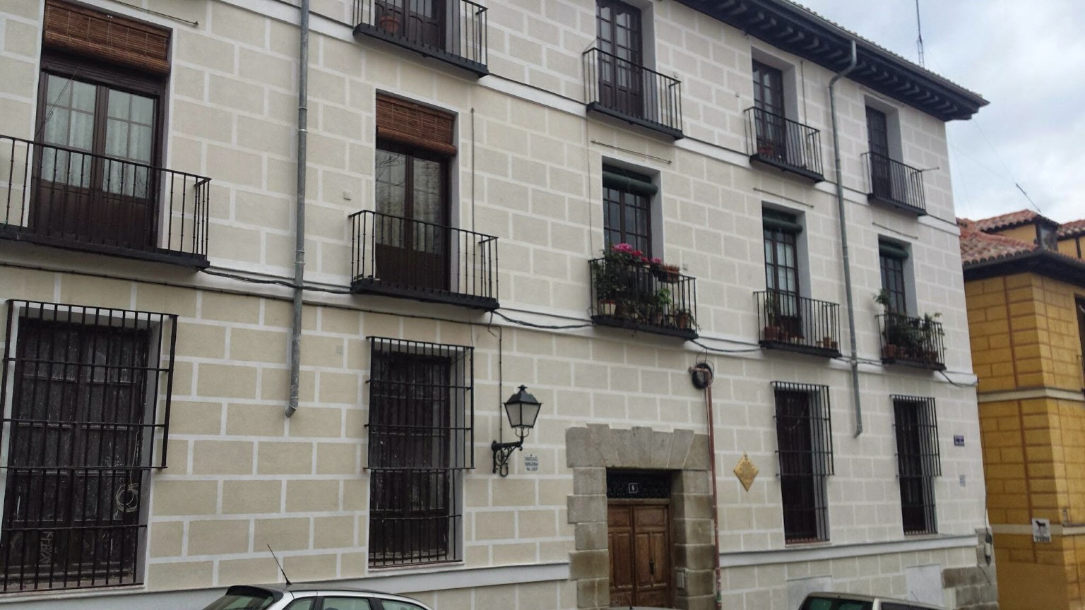 Fachada clara con despiece rectangular y balcones oscuros