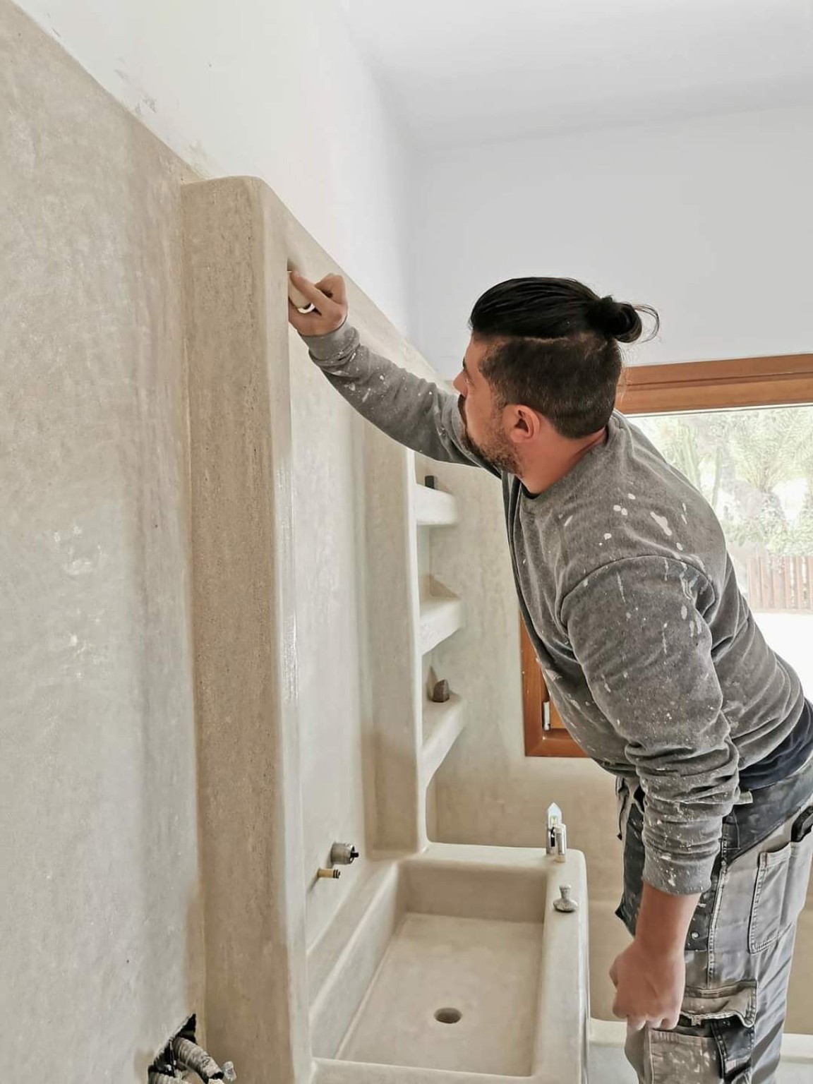 Juan Carlos trabajando el acabado junto a un lavabo